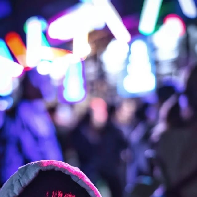 Blurred stage lights over a concert crowd